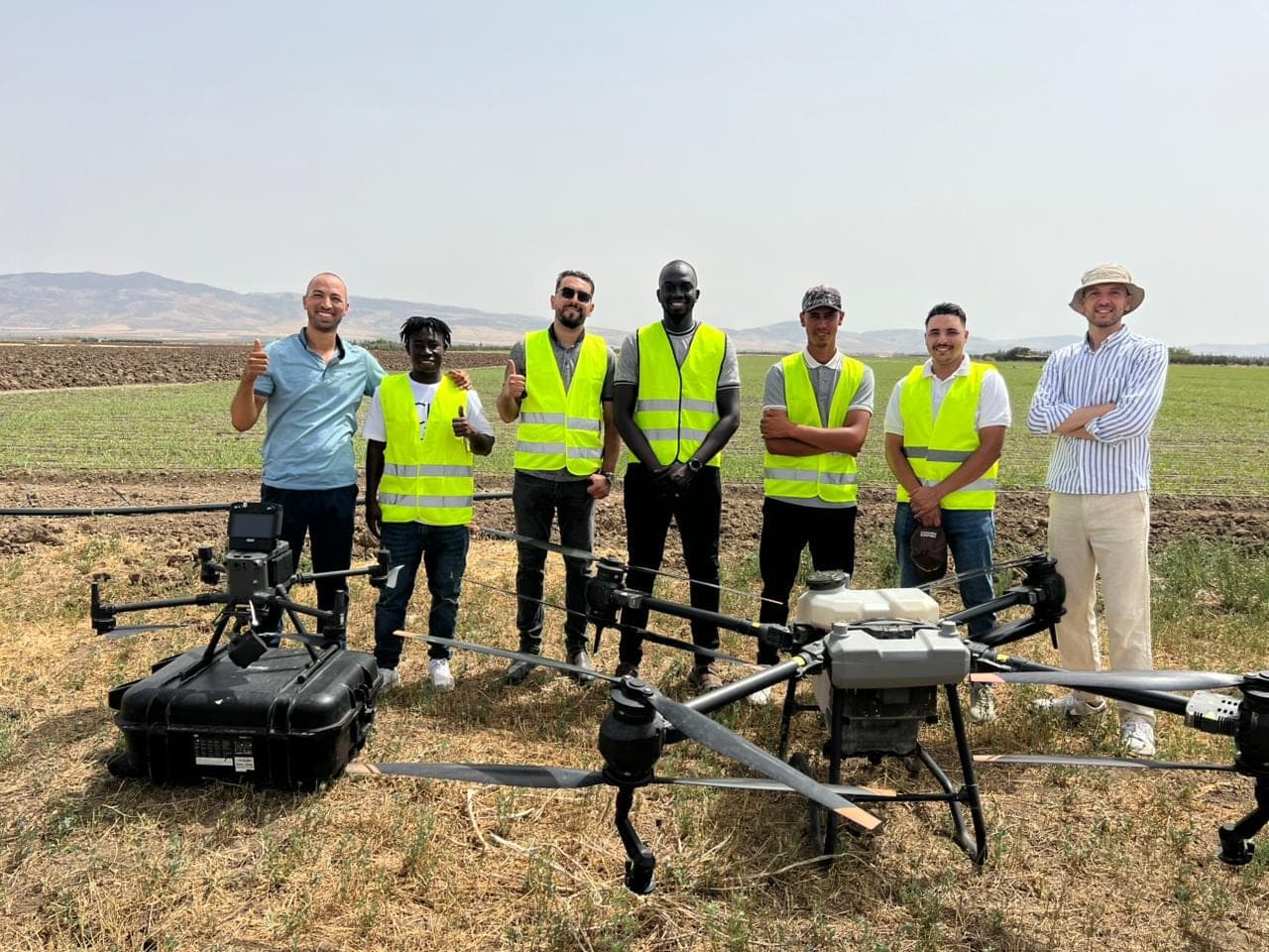 Groupe de participants avec un drone agricole en formation