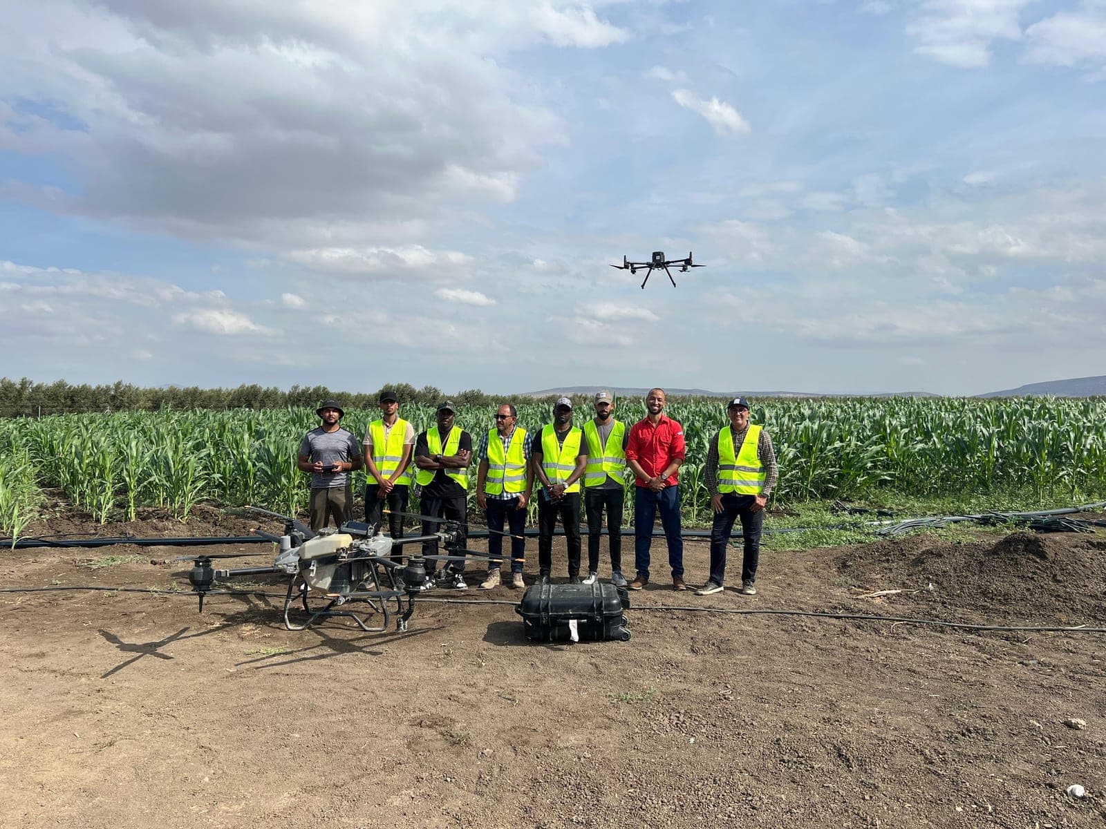 Groupe de participants avec un drone agricole en plein champ