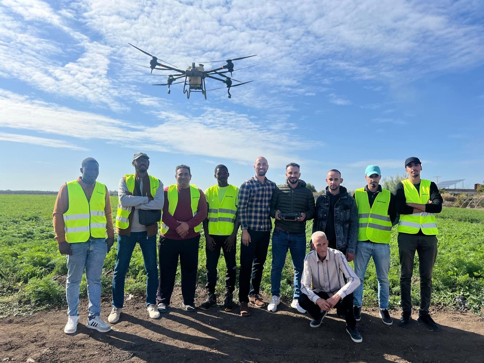 Grand groupe de participants avec un drone en vol