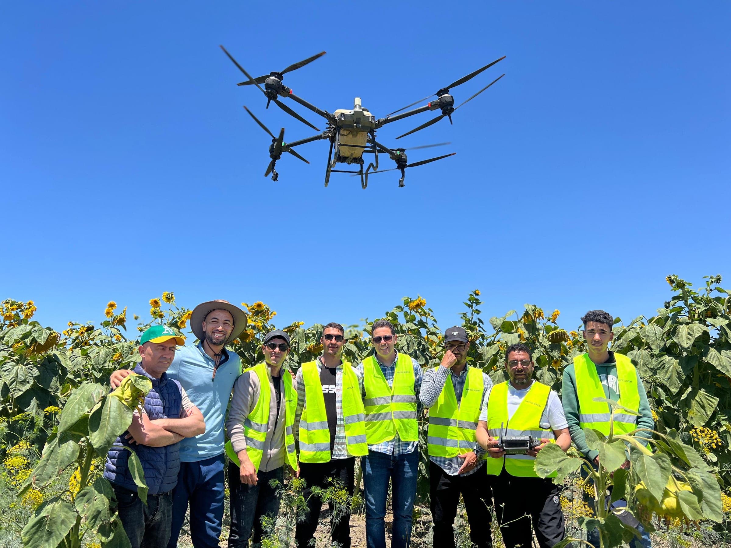 Professionnel africain pilotant un drone agricole au-dessus d'un champ cultivé